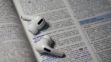 shallow focus photo of wireless earphones on book page