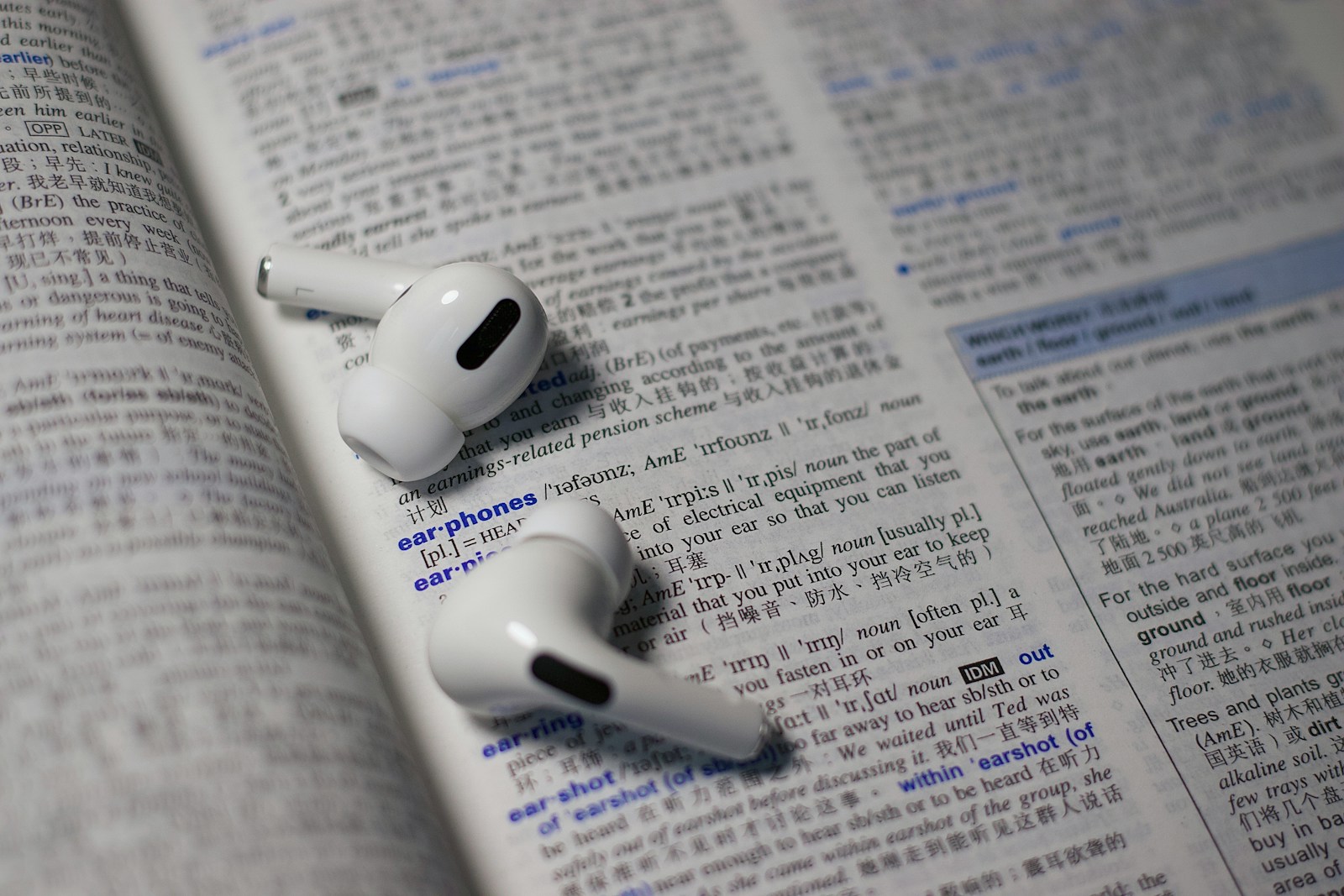 shallow focus photo of wireless earphones on book page