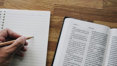 a person is writing on a book with a pencil
